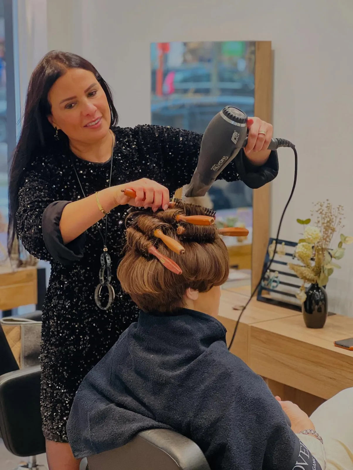 Amal föhnt een klant met ronde borstels in Maison de Coiffure in Knokke
